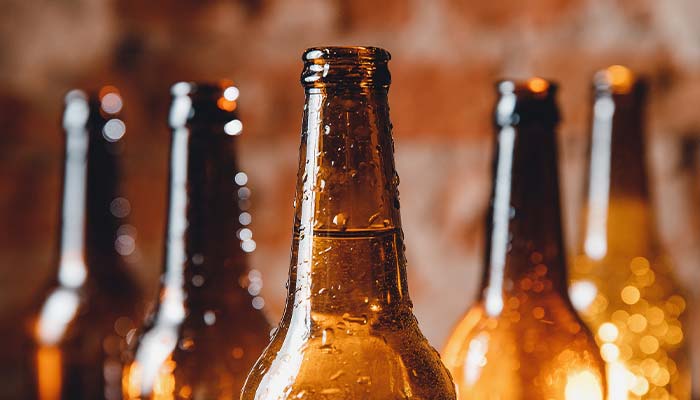 Close-up of several brown beer bottles with condensation, perfect for drinks in Wausau WI.