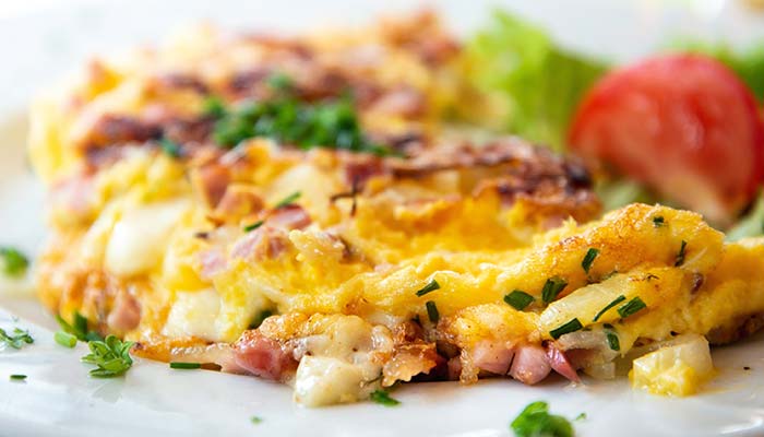 Close-up of a ham and cheese omelette, a breakfast favorite in Wausau WI, with fresh sides.