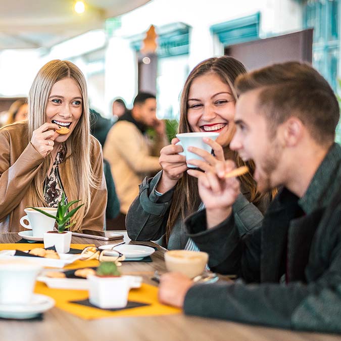 Three friends laugh and enjoy coffee and snacks together at E.J.'s Diner Wausau.