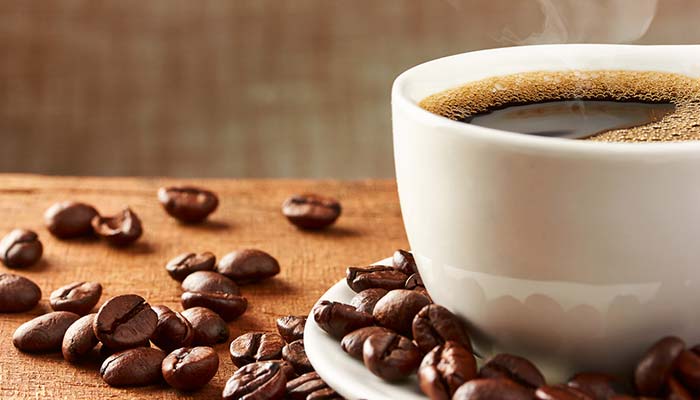 A steaming cup of black coffee sits on a saucer, perfect for drinks in Wausau WI.