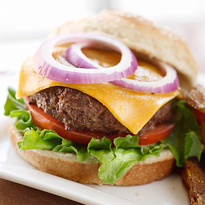 Cheeseburger at E.J.'s Diner Wausau with lettuce, tomato, cheddar, and red onion on a sesame bun.