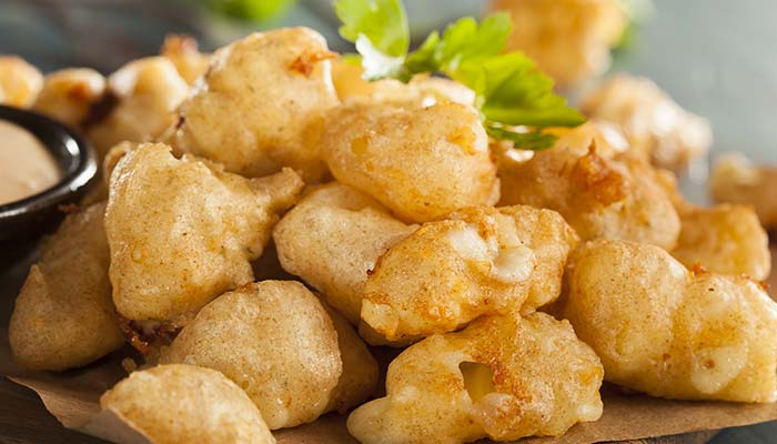Golden, crispy fried cheese curds—perfect for lunch in Wausau, WI—garnished with parsley.