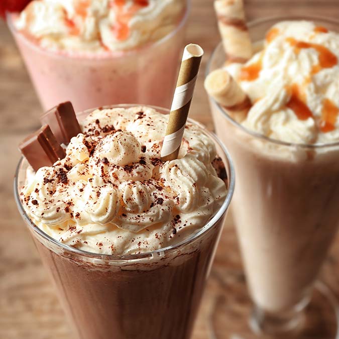 Three milkshakes at E.J.'s Diner Wausau, topped with whipped cream, chocolate, and caramel.